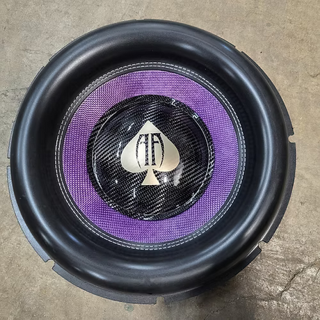 Audio Ace Jester subwoofer with a purple cone and visible brand logo on a concrete floor.