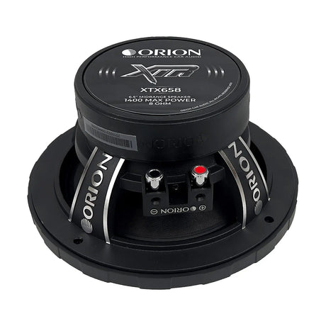 Top-down view of the Orion XTX658 6.5-inch 8-ohm midrange speaker, clearly displaying the symmetrical black cone and silver bullet phase plug centered within a thick, embossed rubber surround. The ORION branding is visible along the outer edge, with the speaker’s circular form and mounting holes evenly spaced around the frame. Cleanly presented on a white background, ideal for showcasing design symmetry and branding on LibertyBassShop.com.
